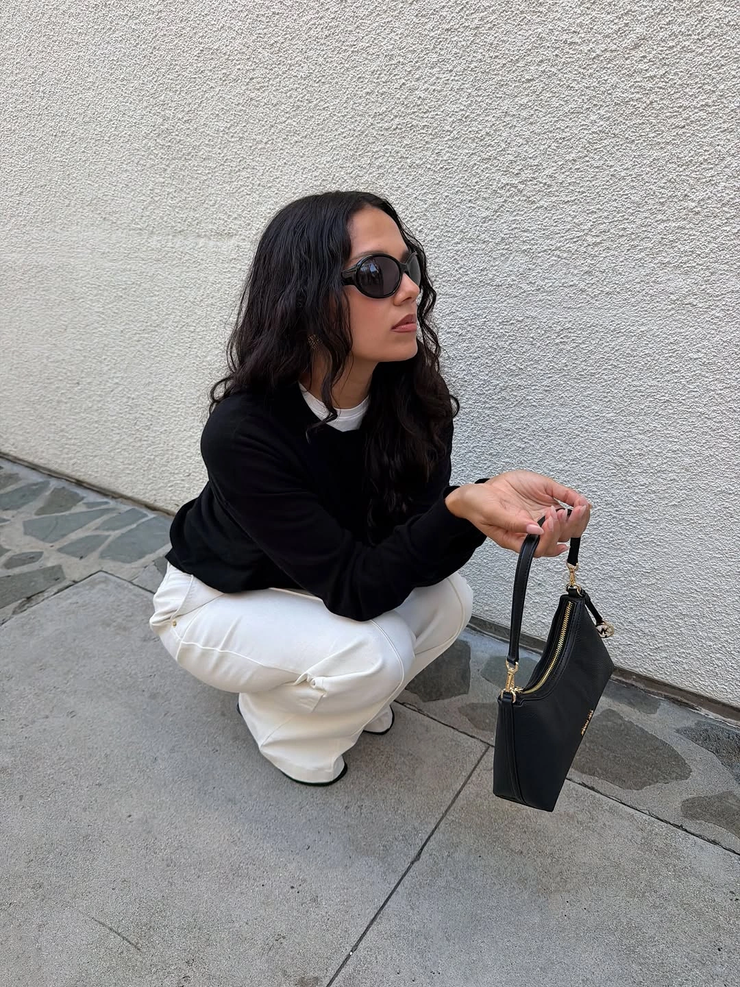 Black sweater with white trousers and black handbag