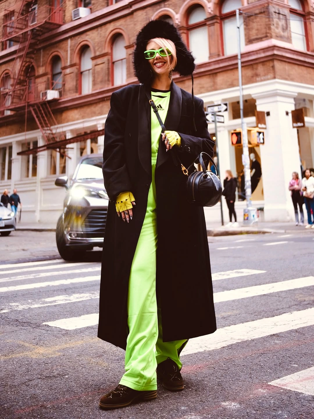 Lime top and wide trousers under long black coat