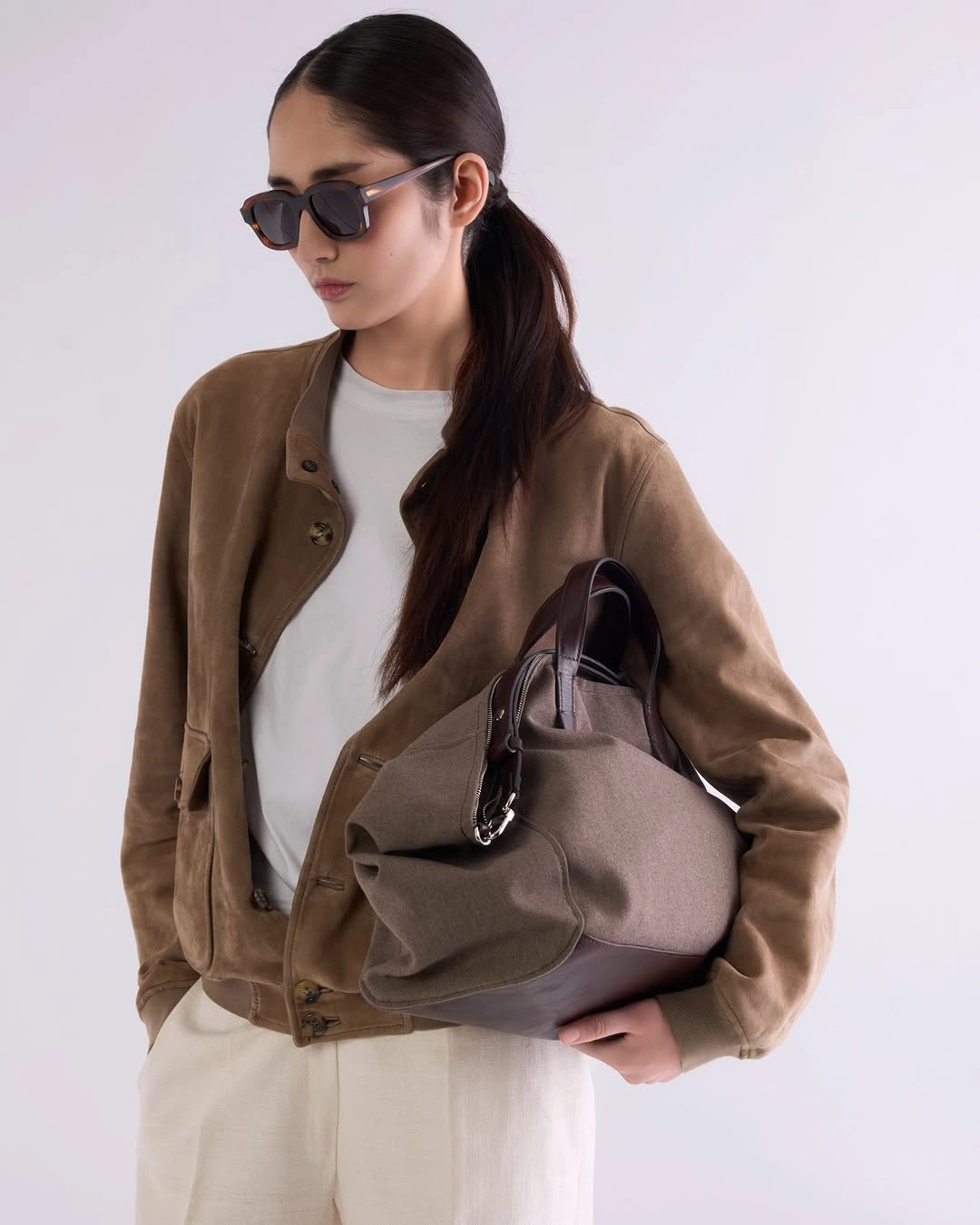 Brown jacket cream trousers and oversized taupe bag