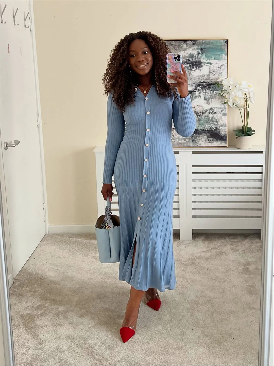 Blue button-front dress with pale bag and red shoes