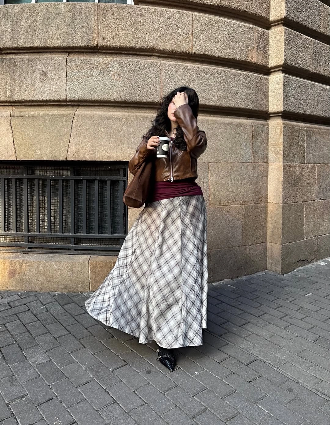 Brown cropped jacket, burgundy layer, long plaid skirt, pointed shoes
