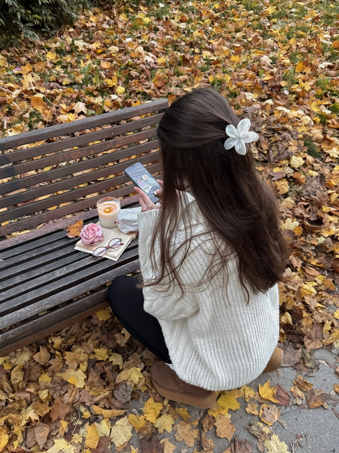 Cream textured sweater, dark leggings, brown boots, pale flower clip