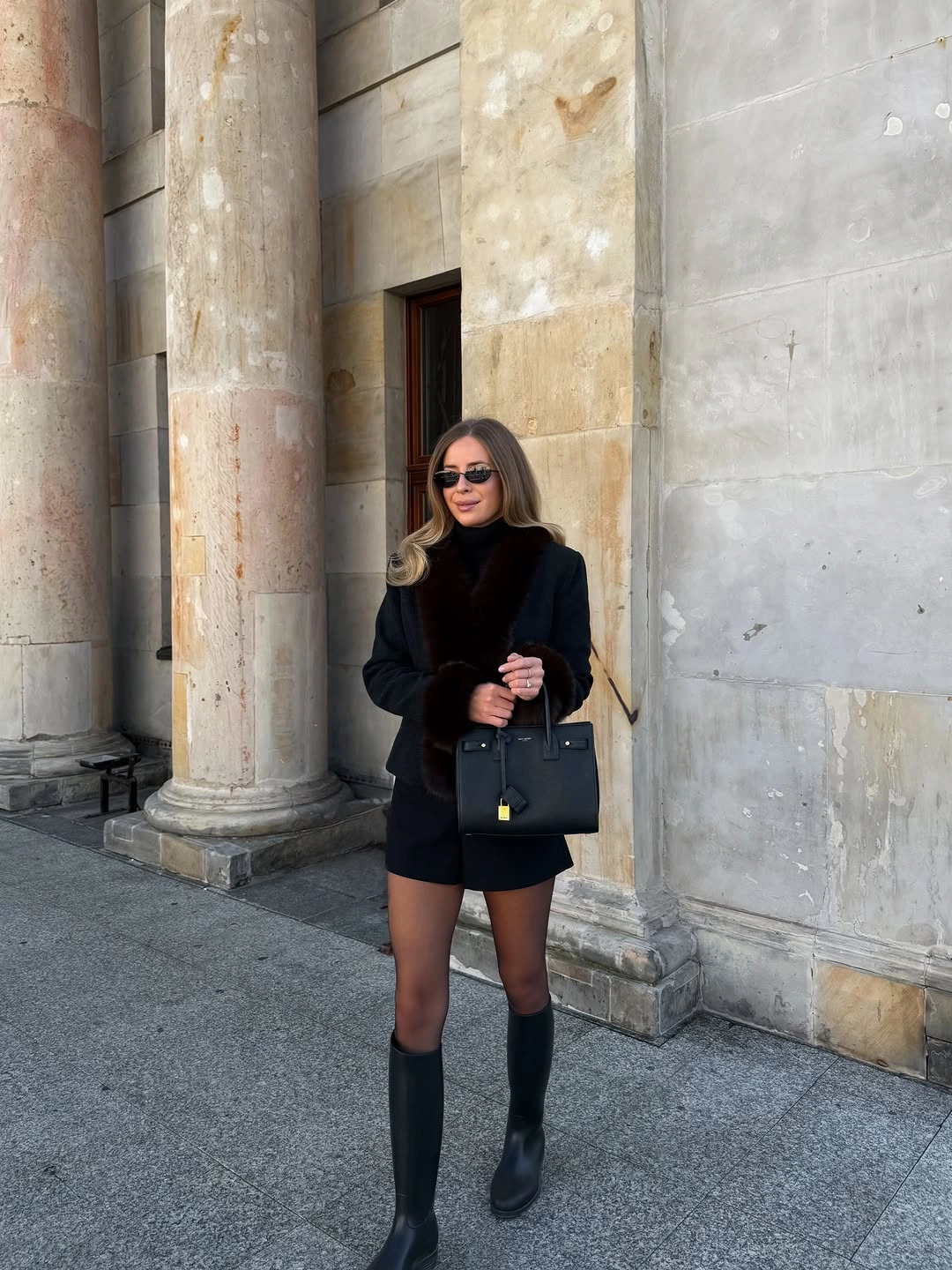 Black blazer, high-neck top, sheer tights, knee-high boots, handbag