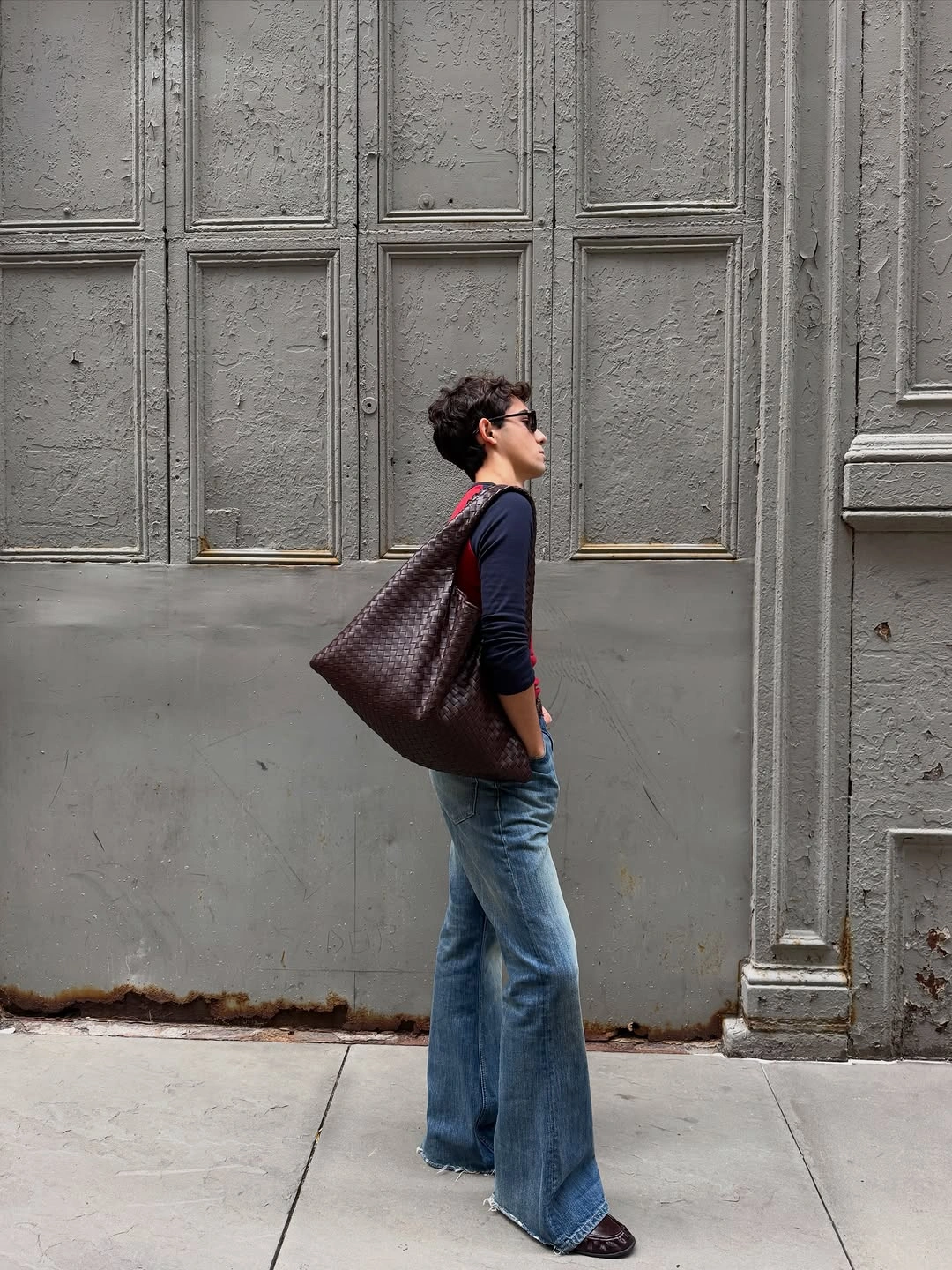 Dark fitted top, wide blue jeans, oversized brown woven bag
