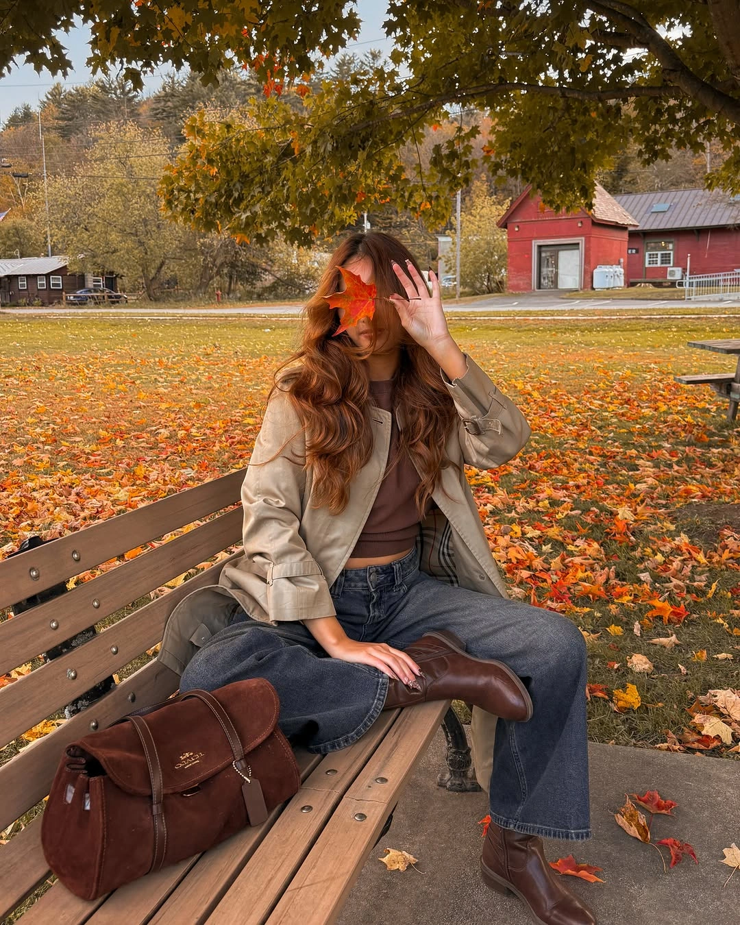 Taupe jacket, brown cropped top, relaxed jeans, boots, and bag