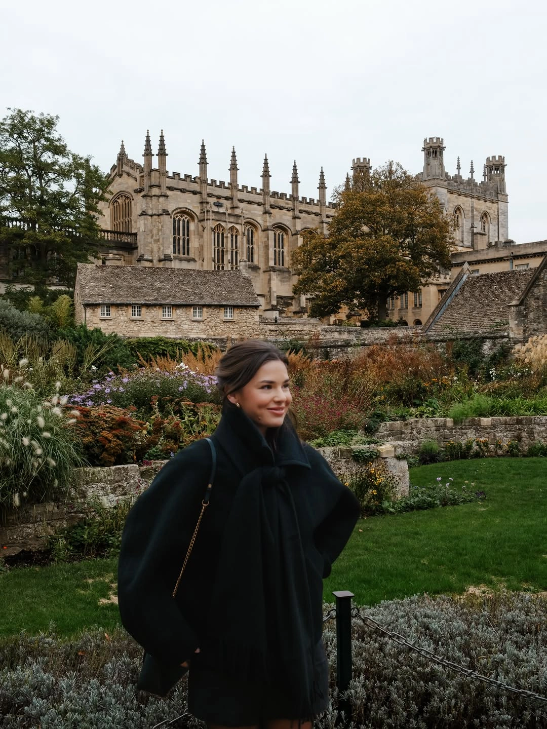 Sculptural black outer layer with broad sleeves and small dark bag