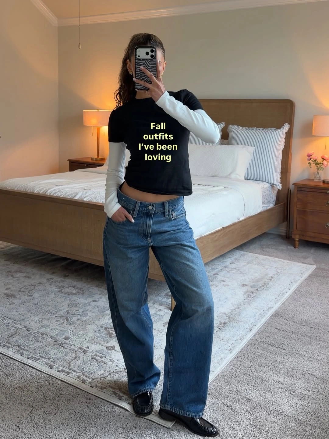 Woman in wide blue jeans with layered black and white tops