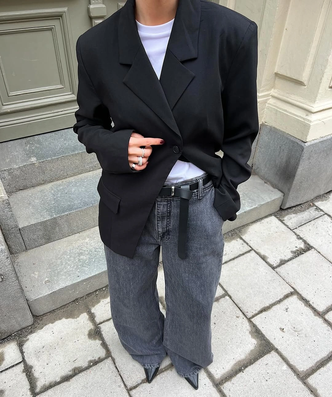 Black oversized blazer with white shirt, gray jeans, and pointed shoes