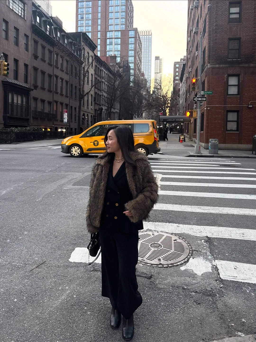 Cropped dark brown textured jacket over long black outfit with boots