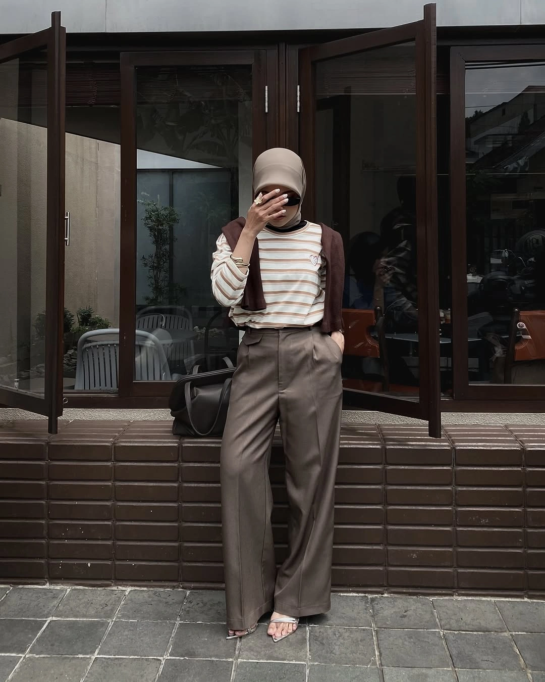 Beige head covering, striped cream top, brown shoulder layer, and taupe trousers