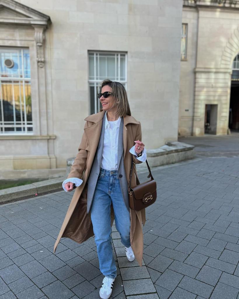 Camel Coat Layered Over Vest and Jeans with White Adidas Sneakers — Classy Adidas Samba Outfits