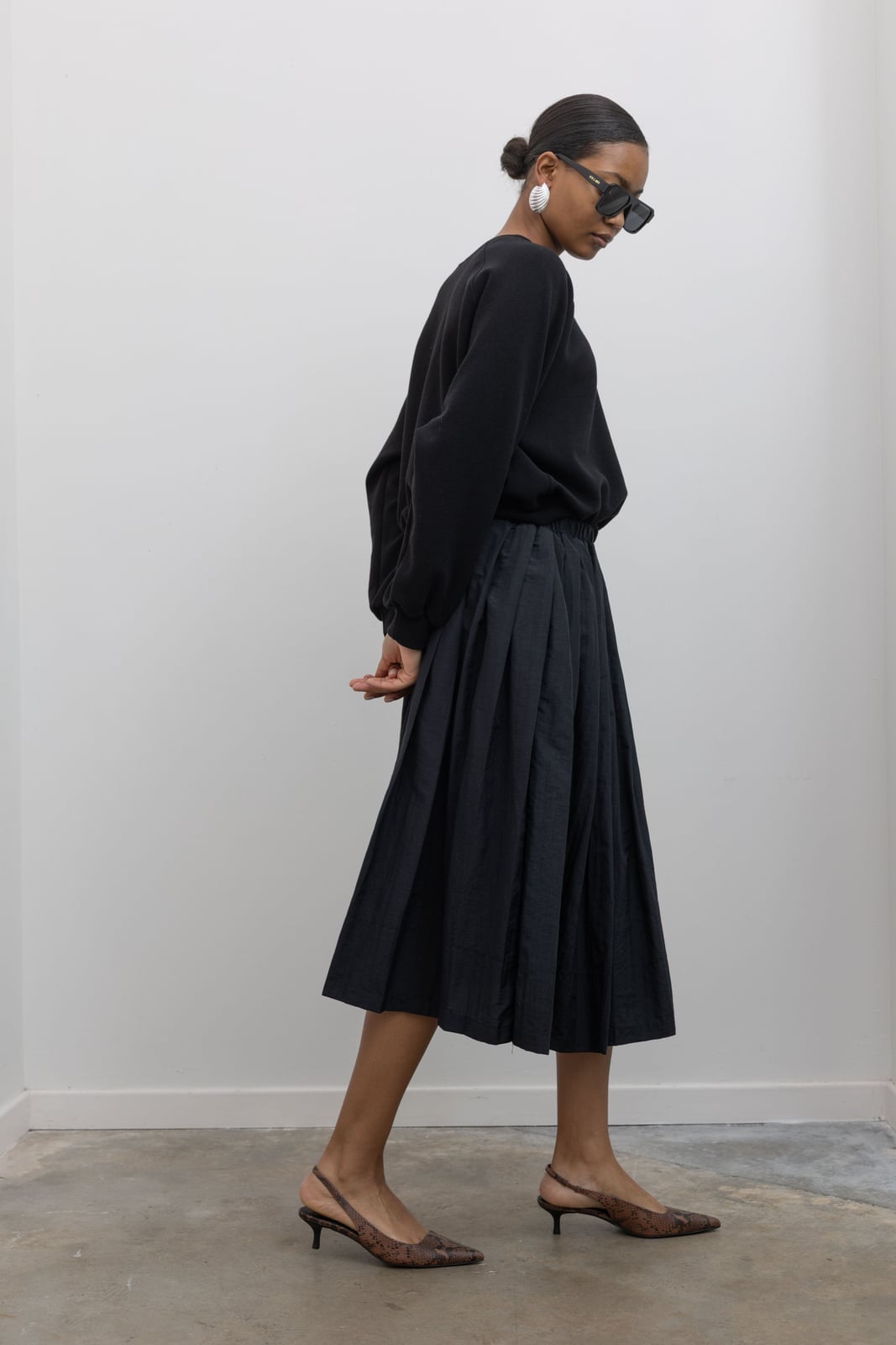Monochromatic Black Pleated Midi Skirt With Sweatshirt Monochromatic Black Pleated Midi Skirt With Sweatshirt — Classy Black Midi Skirt Outfit