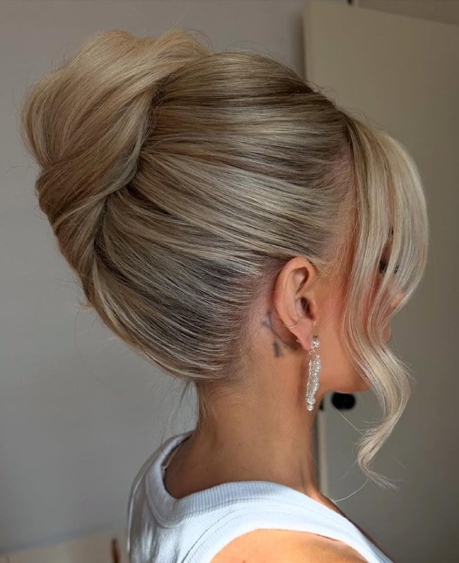 Voluminous Blonde Bun With Swept-Back Waves Voluminous Blonde Bun With Swept-Back Waves — Classy Bridal Bun