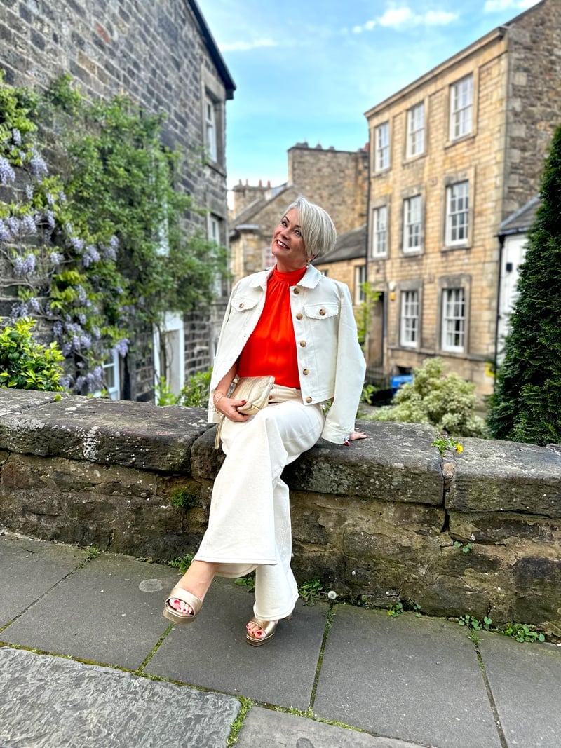 White Denim Jacket Over Orange Top and Cream Trousers White Denim Jacket Over Orange Top and Cream Trousers — Classy Hot Weather Outfits