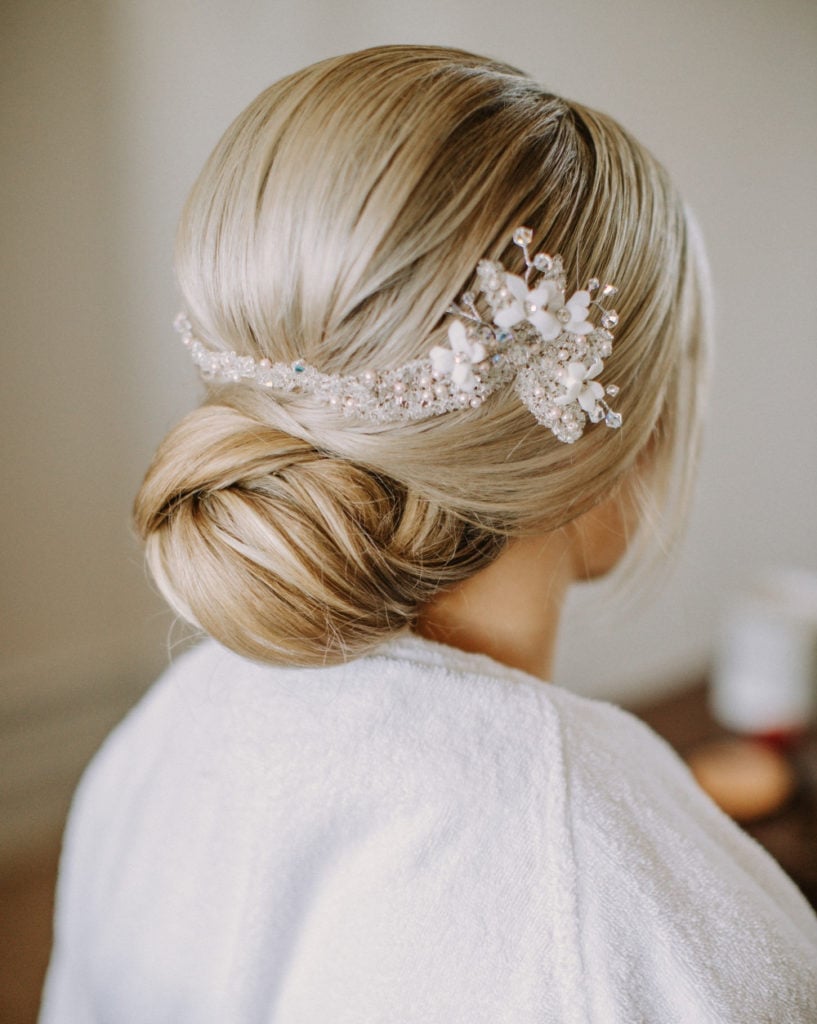 Blonde Sleek Low Bun With Crystal Accessory Blonde Sleek Low Bun With Crystal Accessory — Classy Low Bun Wedding Hair