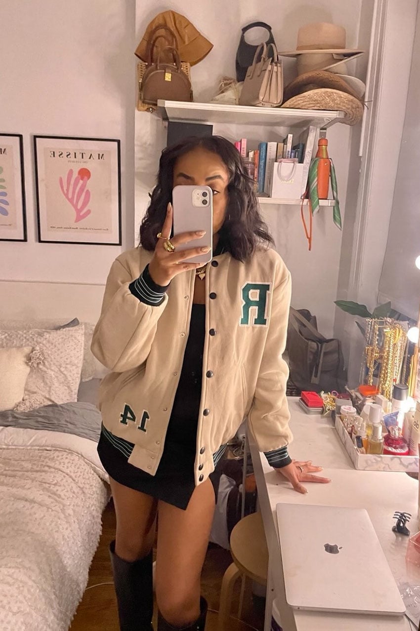 Cream Varsity Jacket with Green Trim Over a Black Mini Dress Cream Varsity Jacket with Green Trim Over a Black Mini Dress — Classy Varsity Jacket Outfits