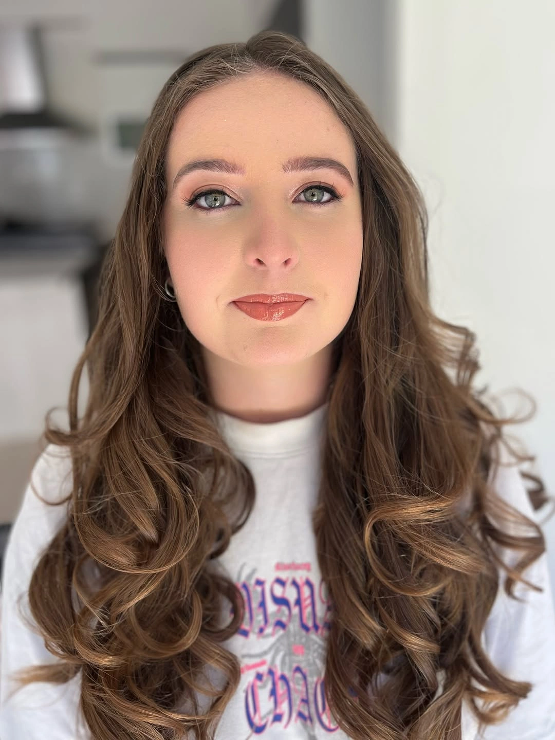 Long center-parted brown hair with caramel reflections and curled ends
