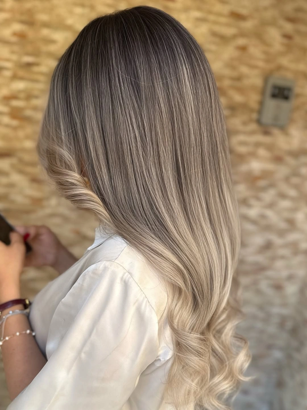 Long smooth ash beige hair fading into pale curled blonde ends