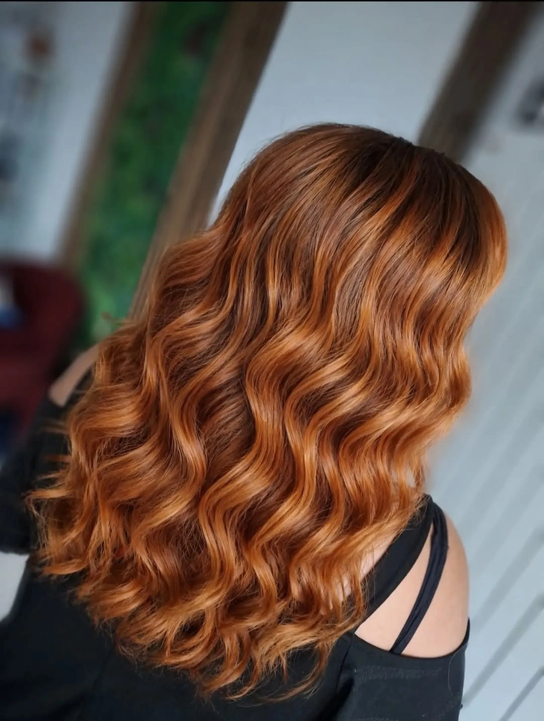 Medium length copper orange hair with glossy sculpted S shaped waves