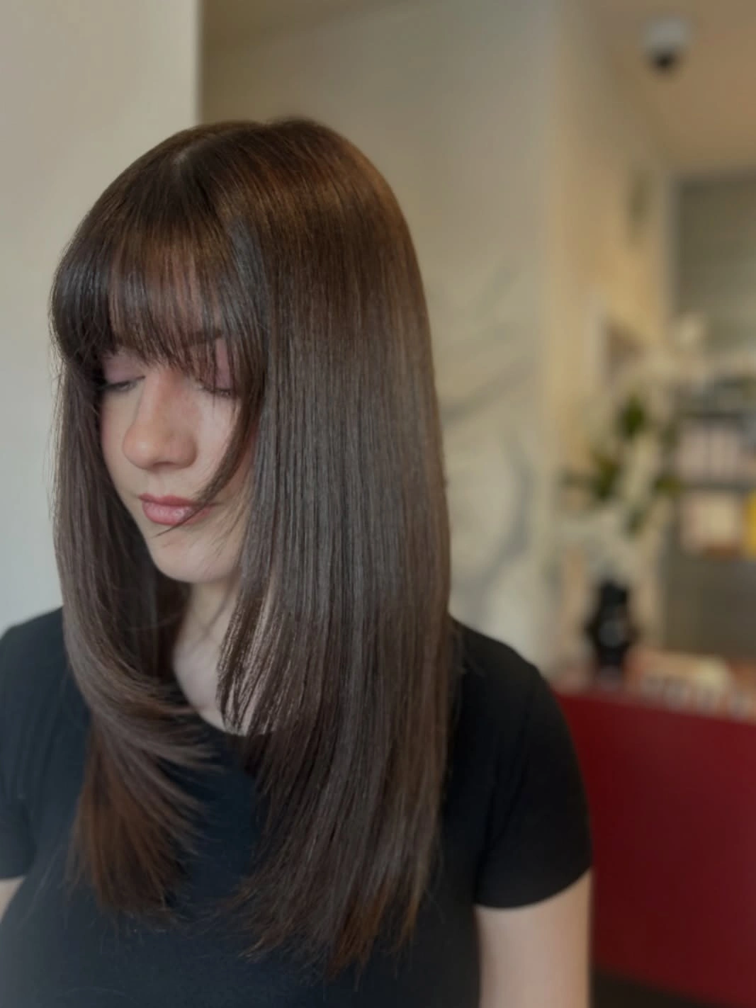 Cool ash brown shoulder-length hair with full bangs and tapered ends