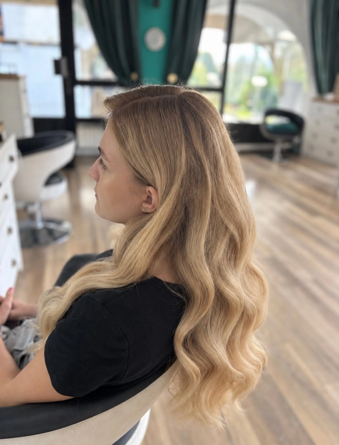 Long cream-gold blonde hair with deeper beige roots and loose waves