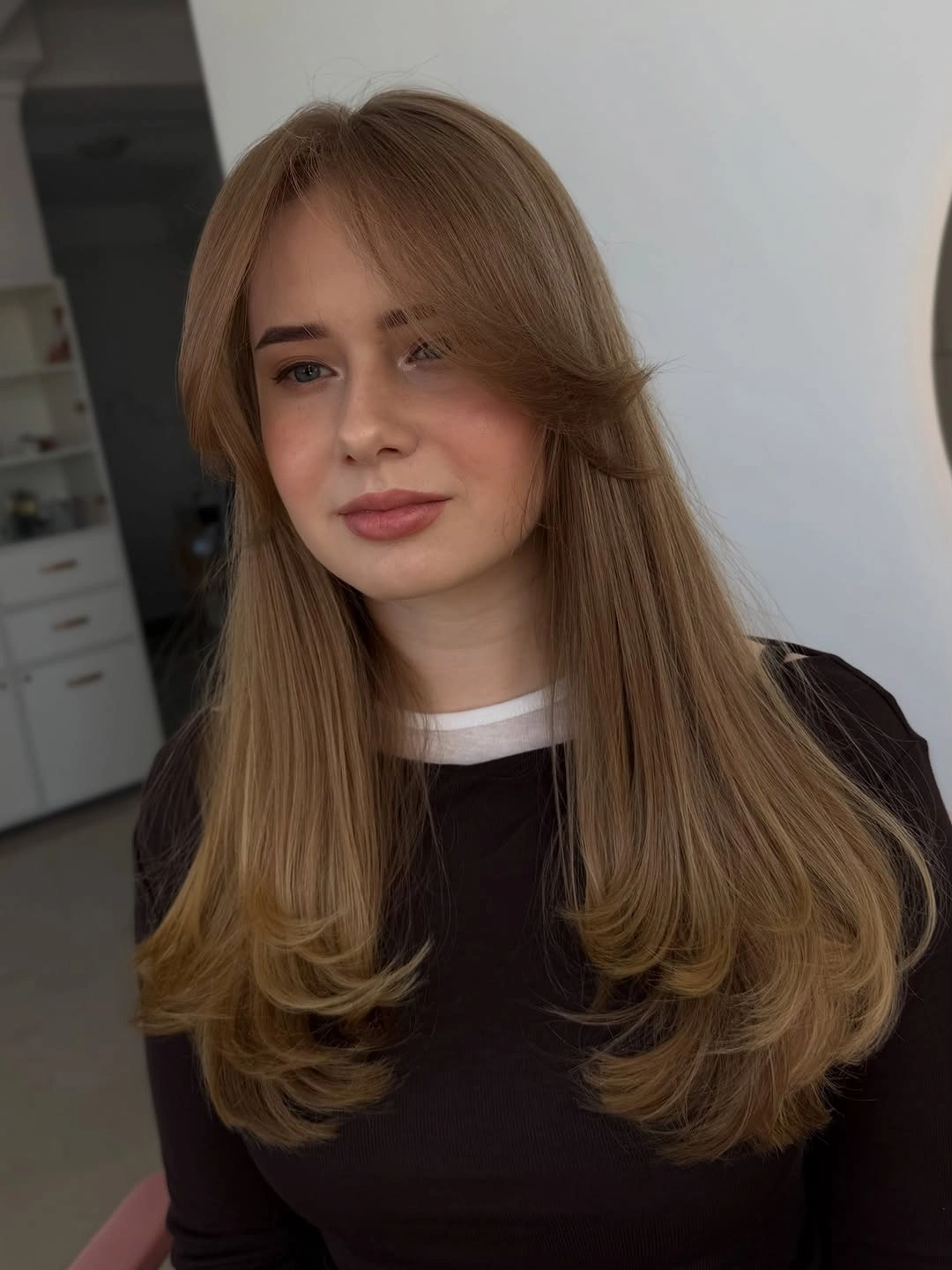 Long light-brown layered hair with center-parted face framing