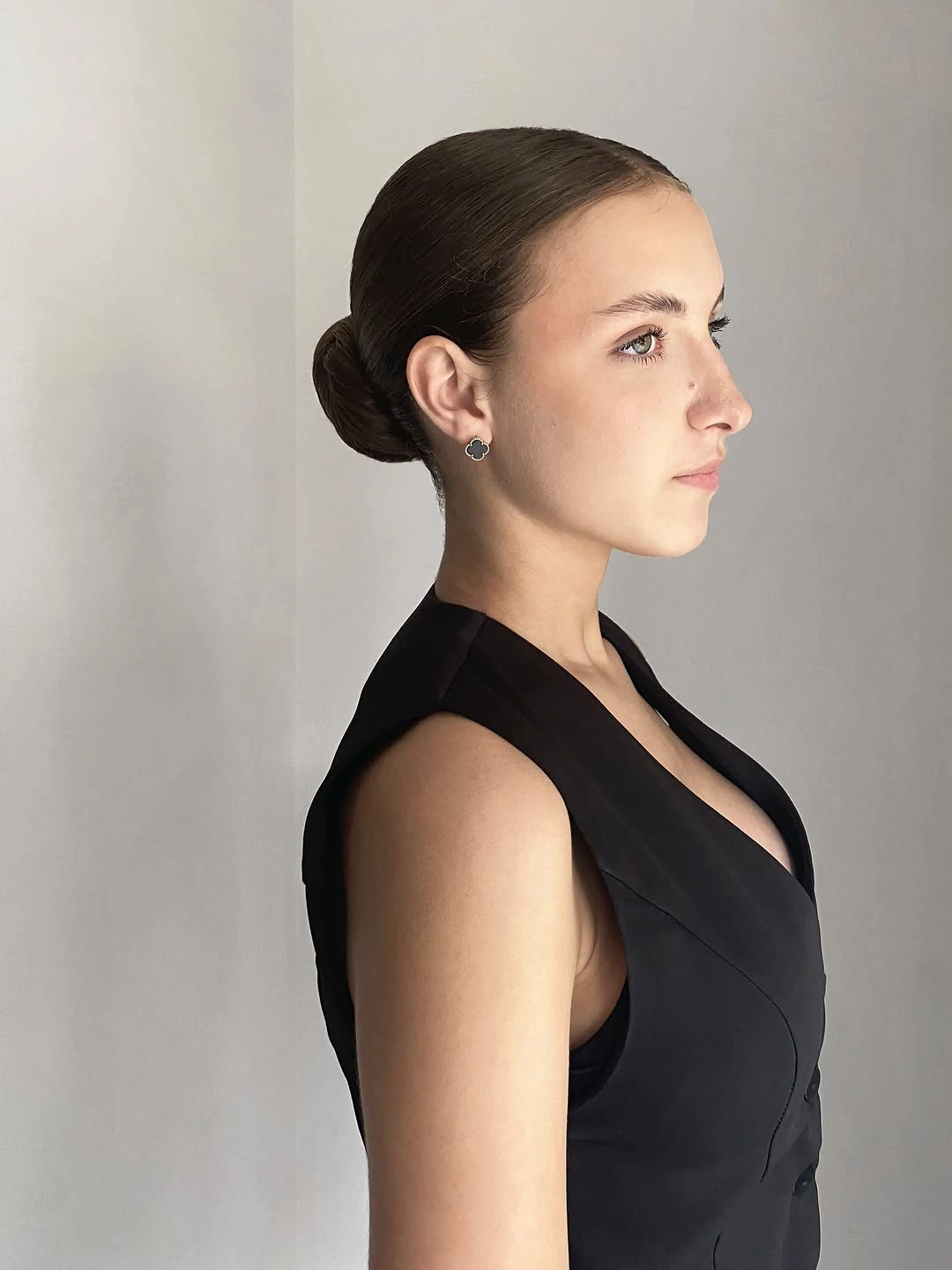 Sleek dark hair pulled into a compact low bun
