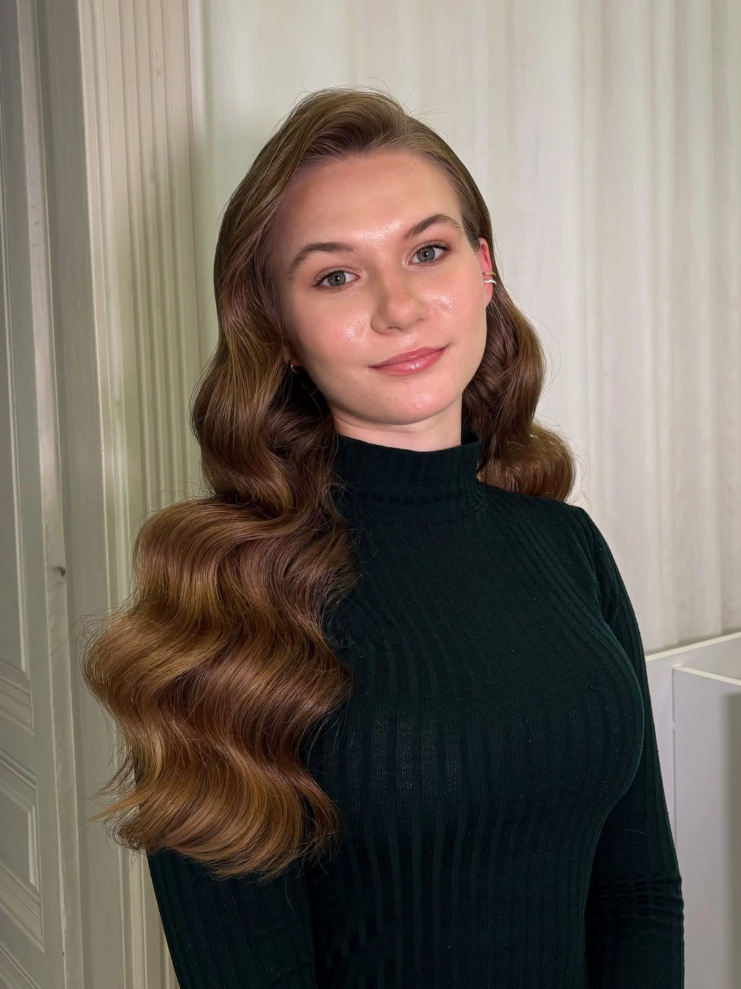 Long warm brunette hair with side part and polished waves