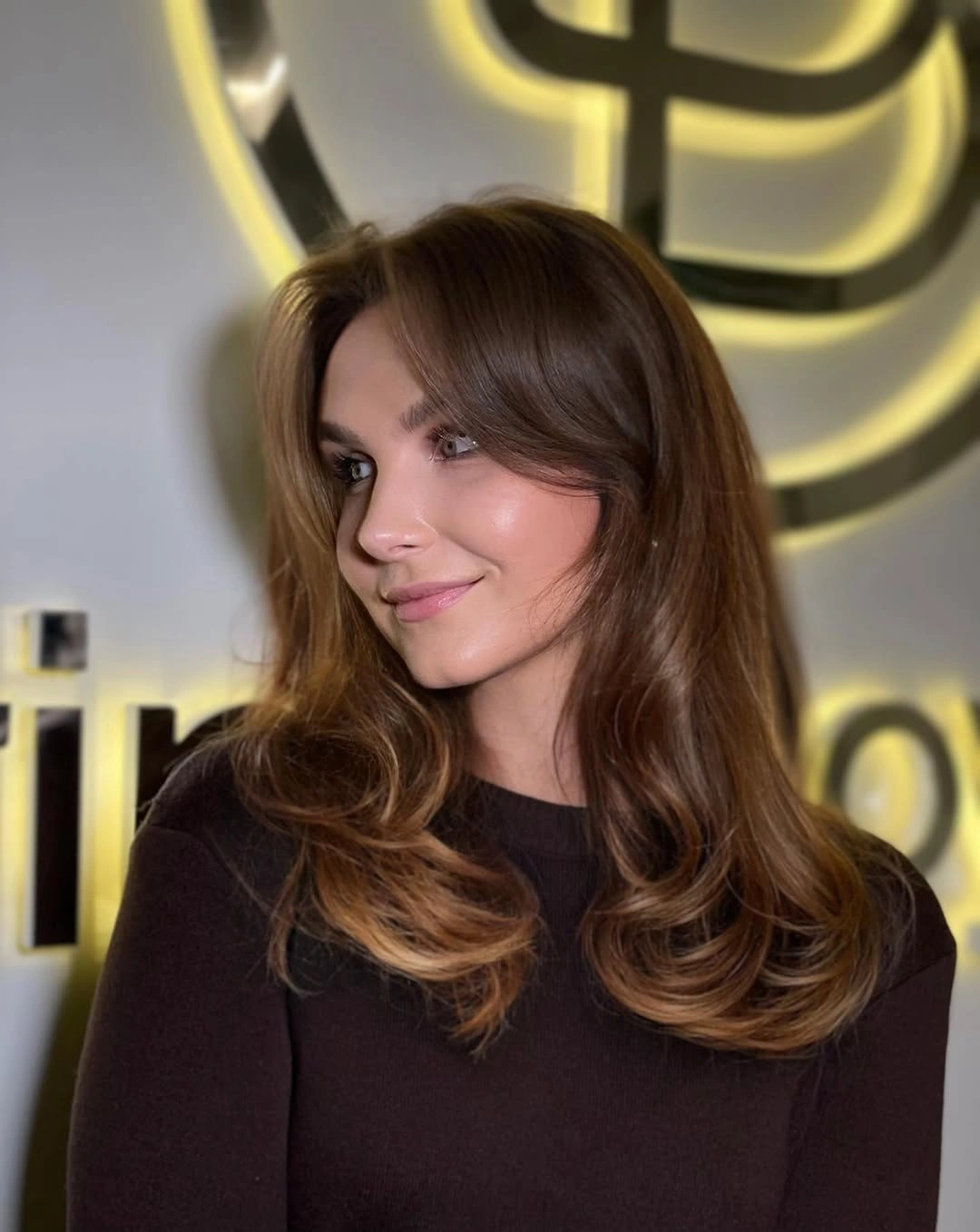 Chestnut layered hair with curved ends and center-parted framing