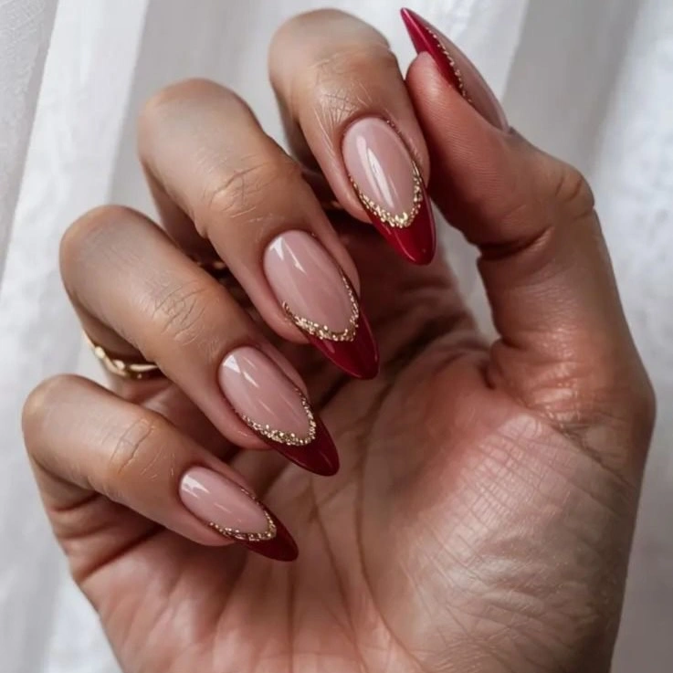Long almond nails with burgundy pointed French tips and dotted gold borders