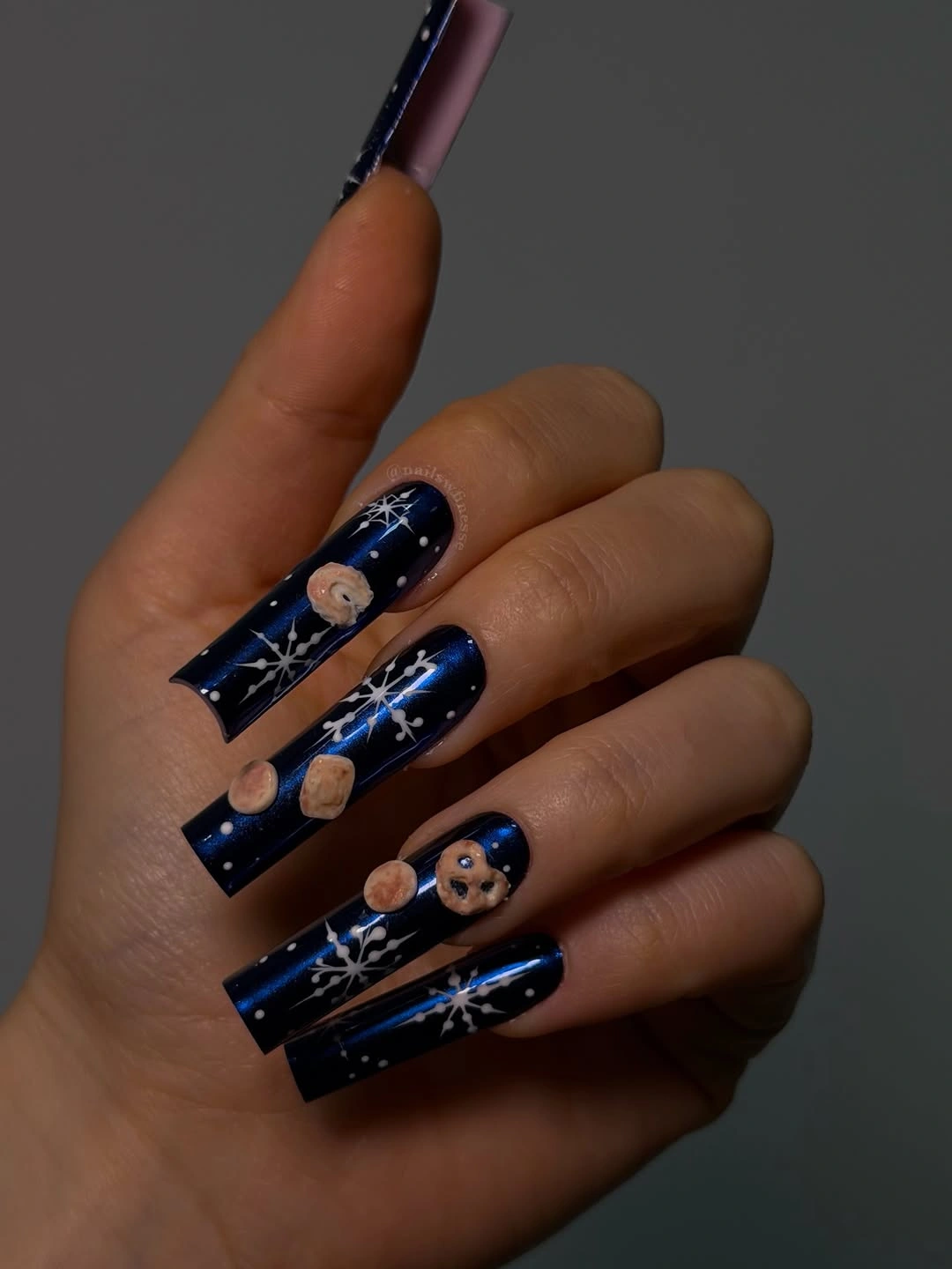 Extra long square navy nails with white snowflakes and tan circular illustrations