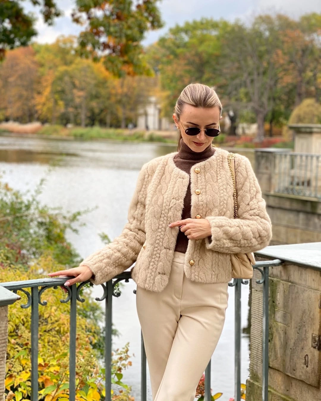 Cream textured button jacket with light trousers and pale quilted shoulder bag