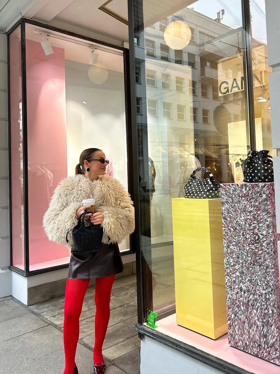 Shaggy ivory jacket, dark mini skirt, red tights, and dark red shoes