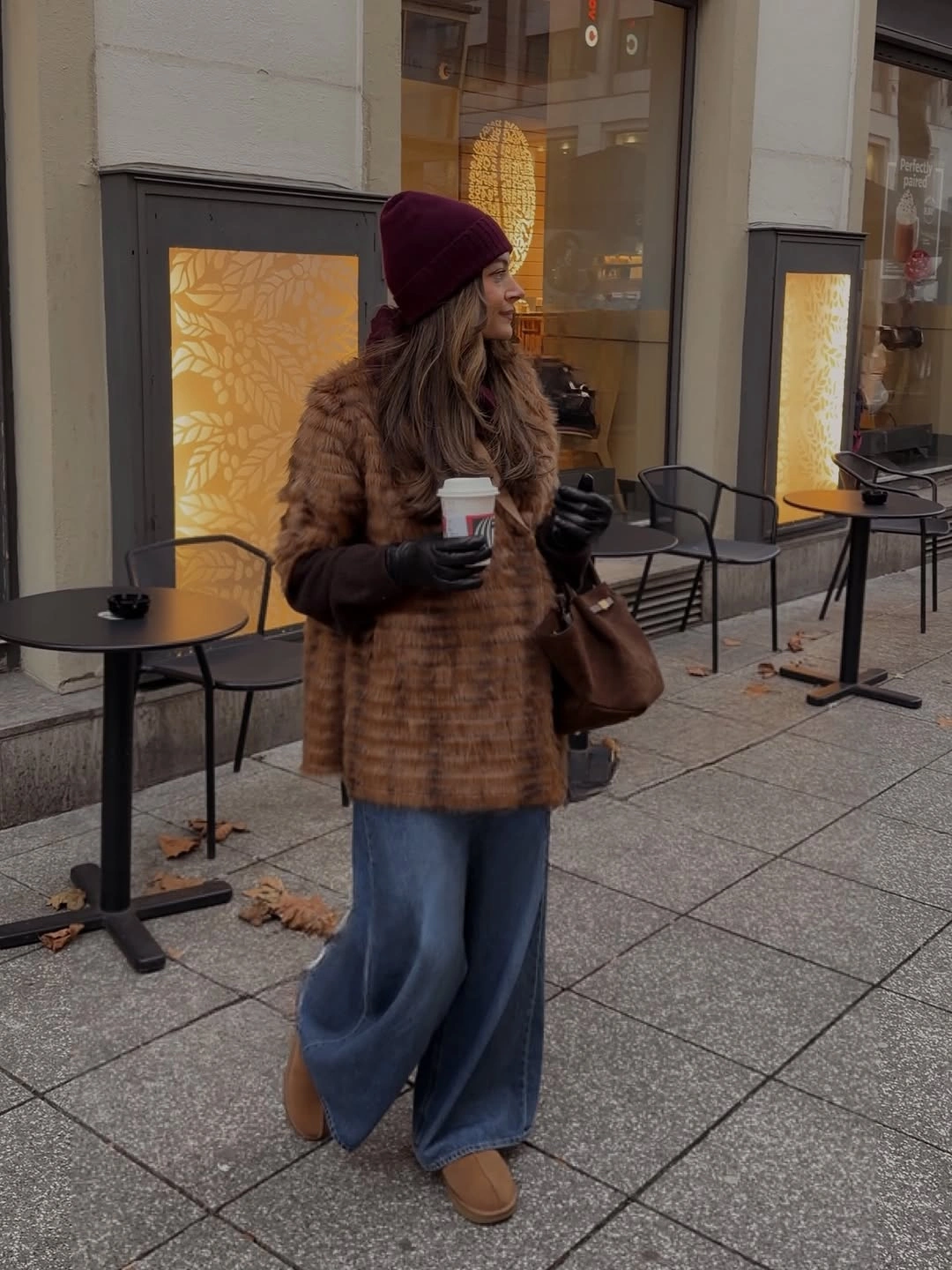 Textured brown jacket with wide blue jeans, burgundy beanie, and tan shoes