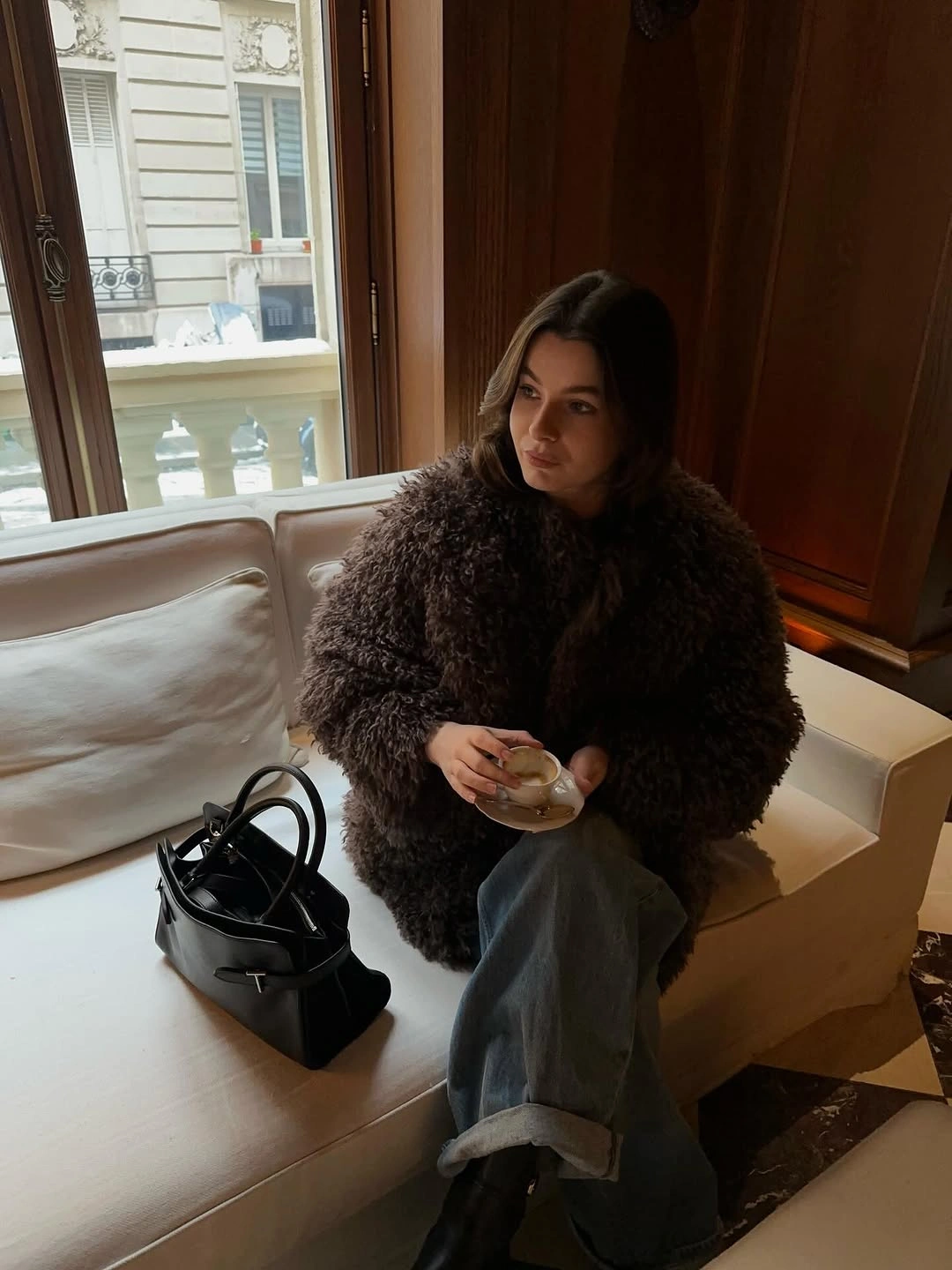 Dark brown shaggy jacket with cuffed gray jeans and structured black handbag