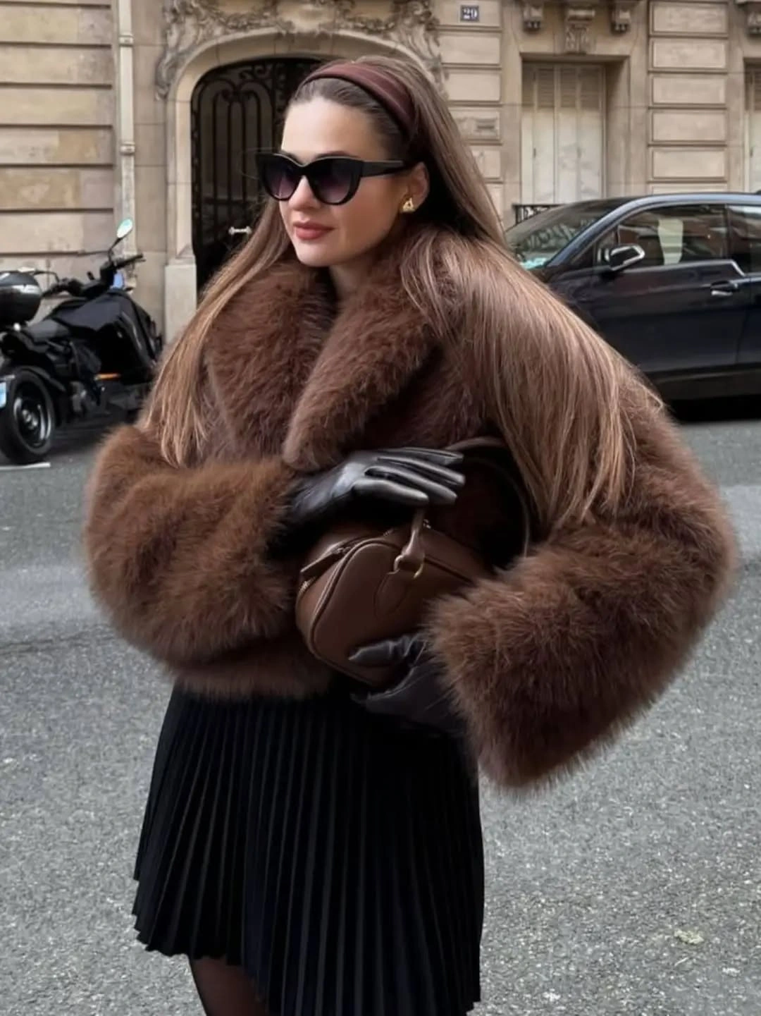 Brown plush textured outer layer with black pleated skirt gloves and handbag
