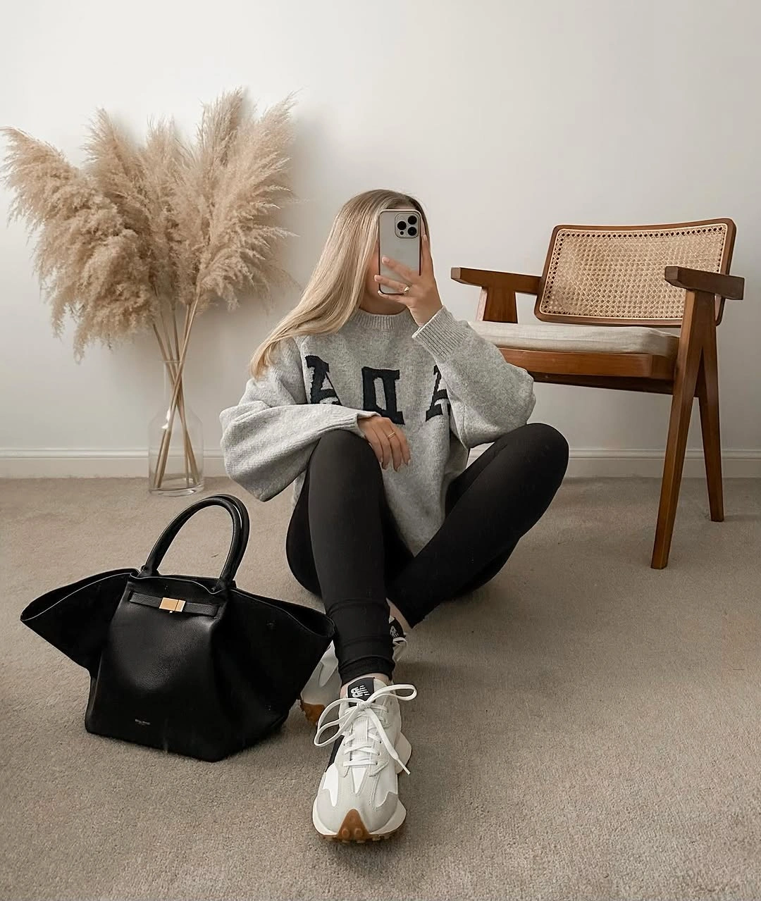Gray lettered sweatshirt with black leggings, light sneakers, and large black tote.