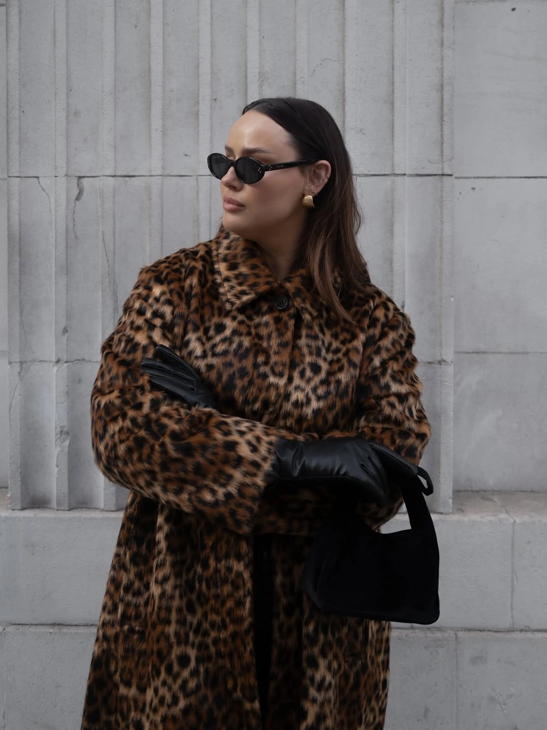 Brown leopard-pattern coat with black gloves, sunglasses, and dark handbag.