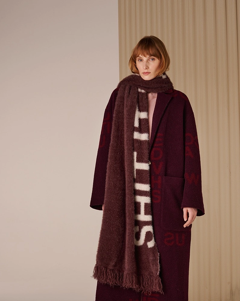 Long burgundy coat with oversized dark scarf pale lettering and pink layer