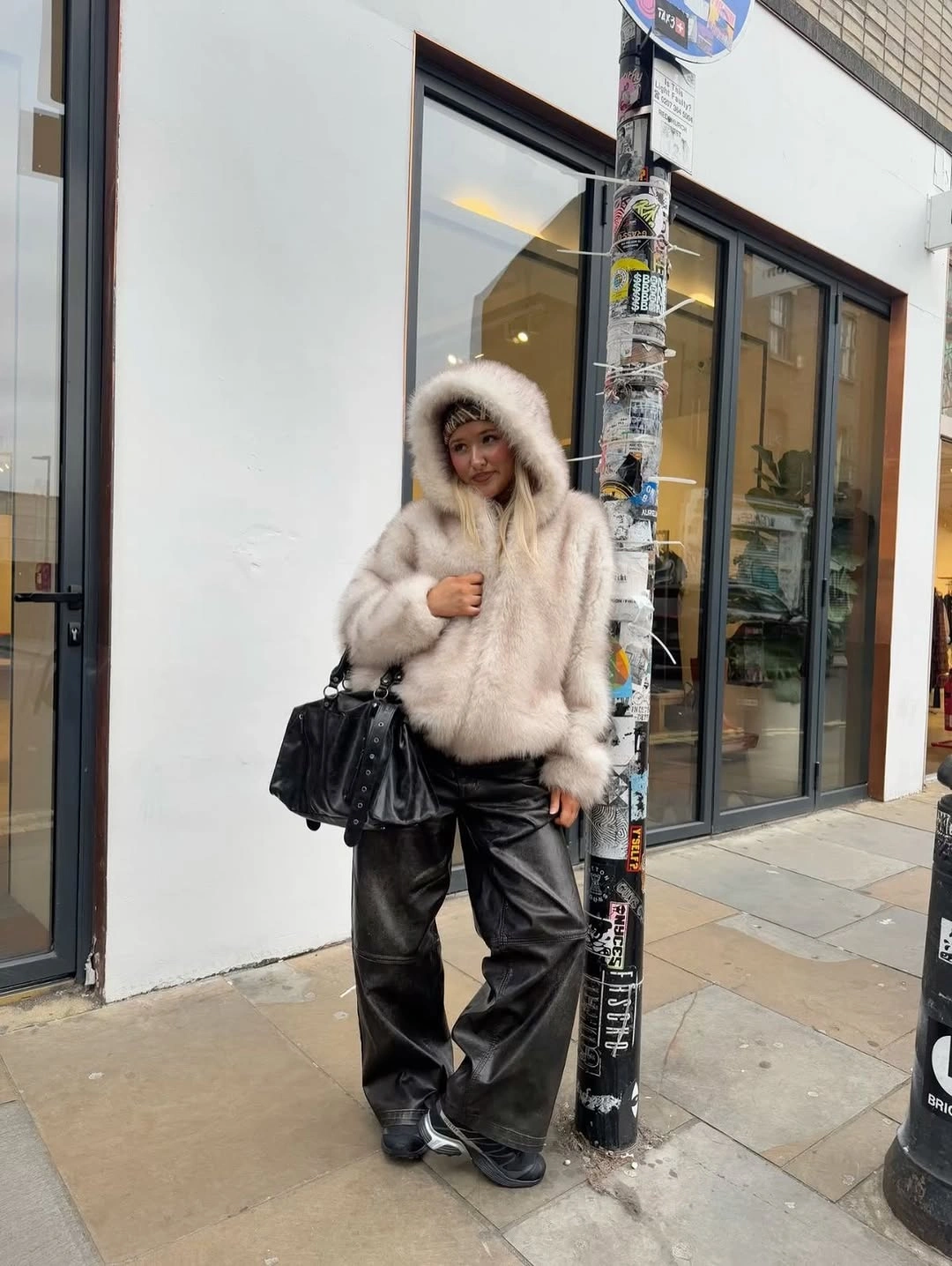 Fluffy ivory hooded jacket with wide black pants and dark shoes