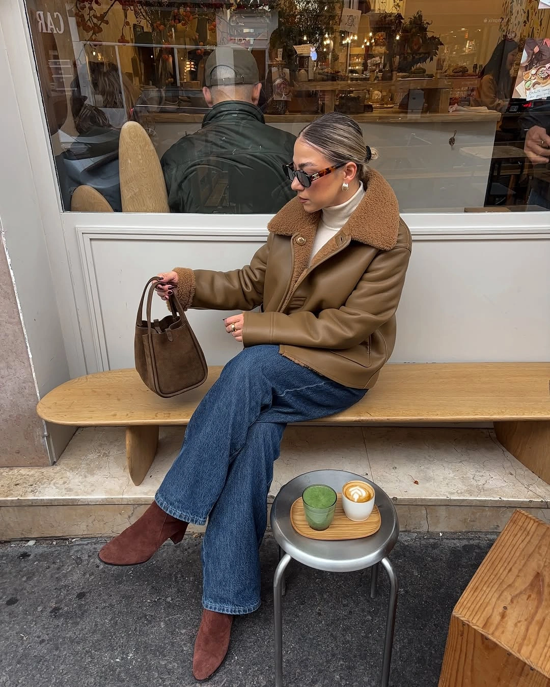 Camel brown jacket white high neck top blue jeans and reddish brown boots
