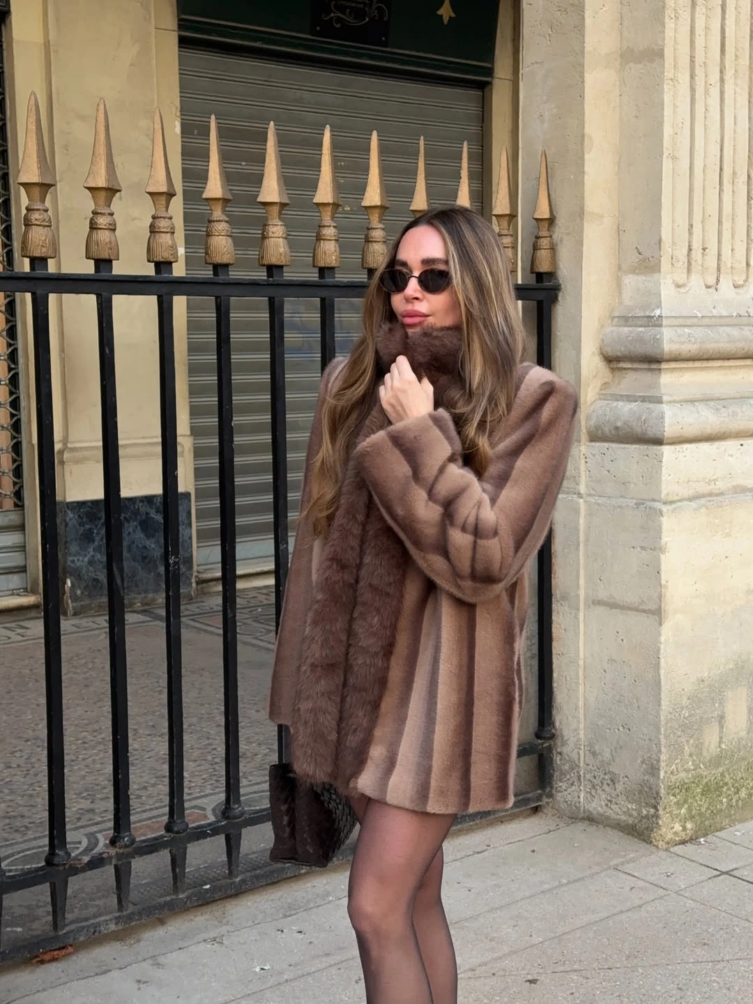 Short plush brown coat with broad collar sunglasses and sheer tights