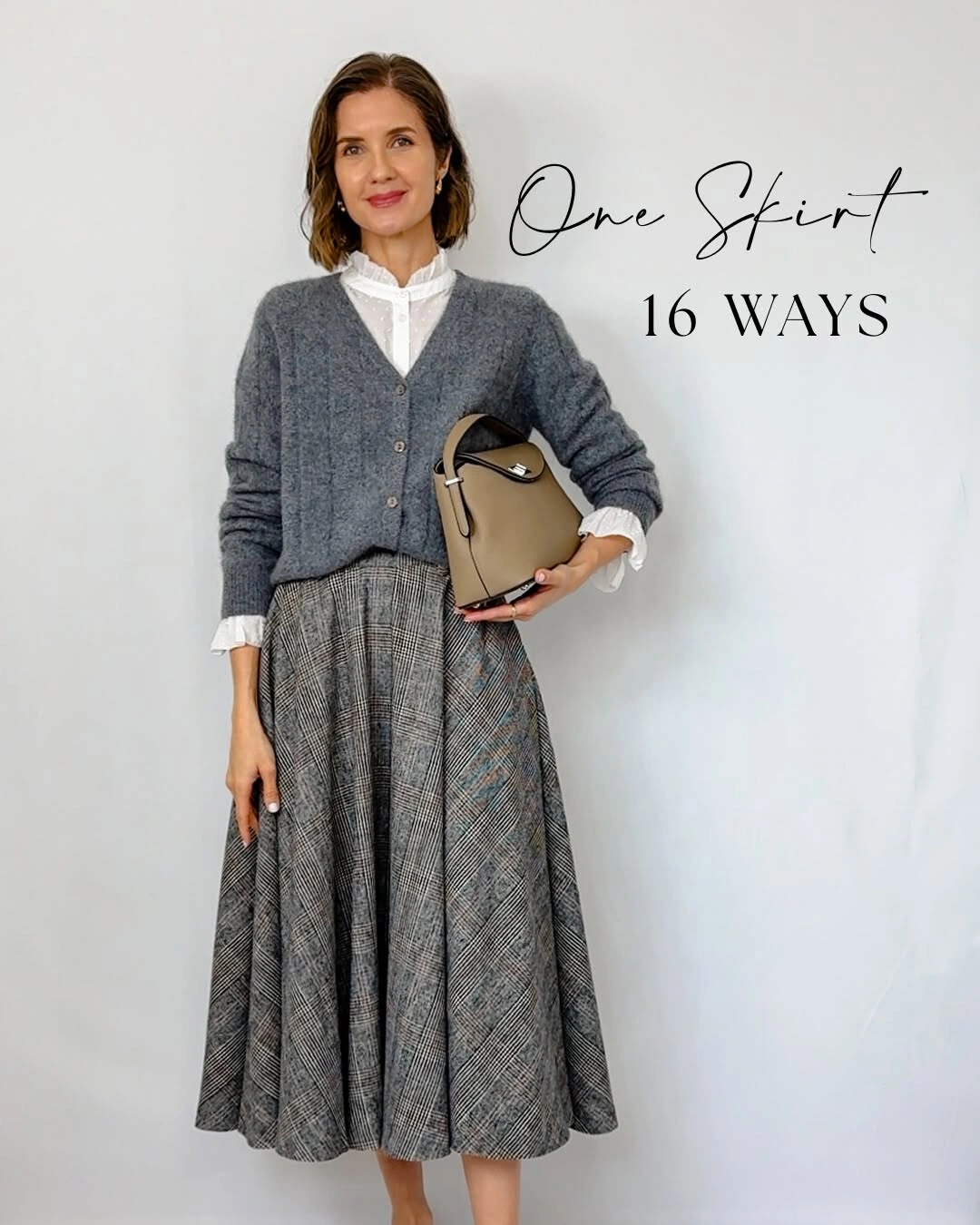 Gray cardigan over white blouse with full plaid skirt and taupe handbag