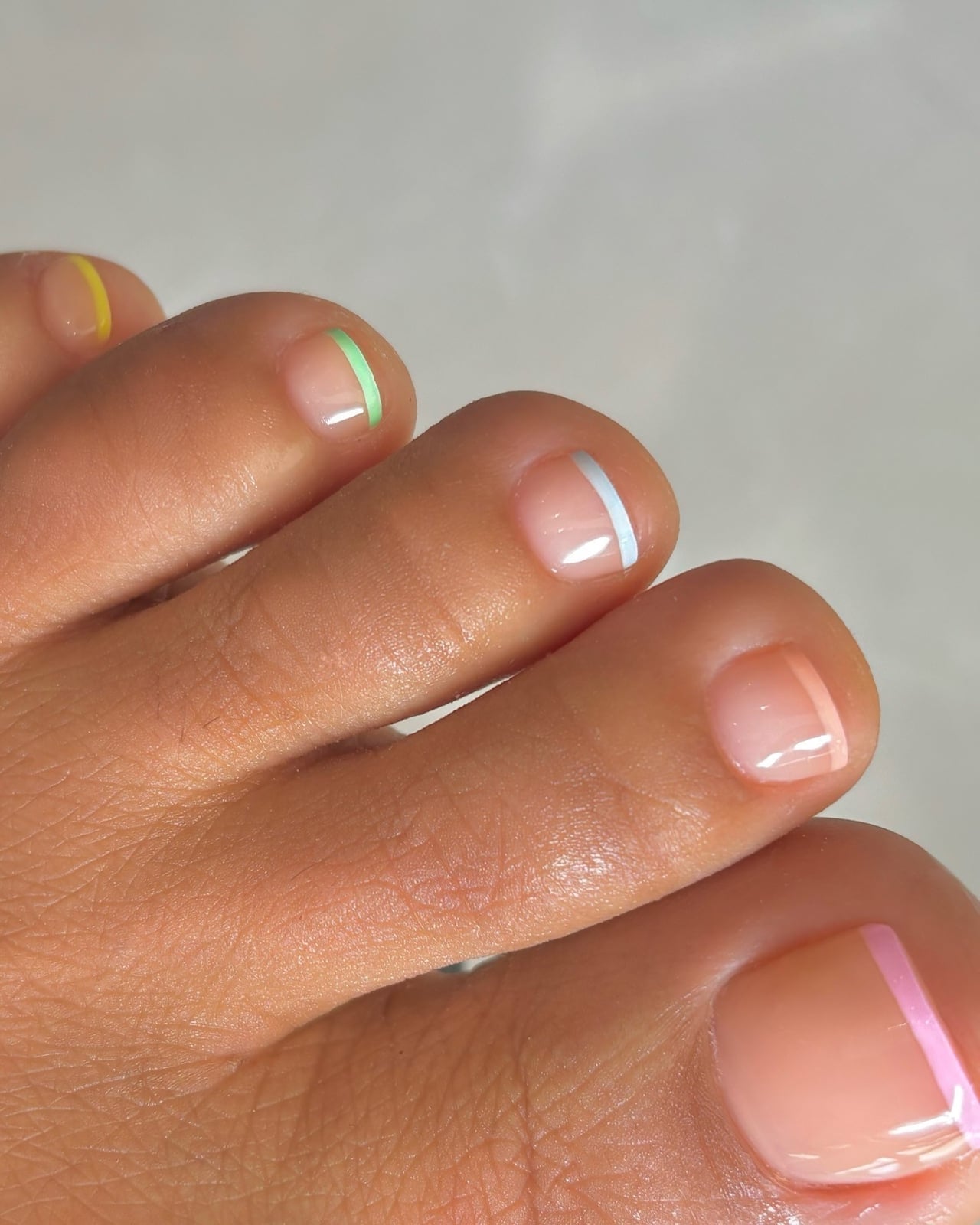 Sheer Nude Glossy Short Square with Pastel Edge Lines, Close-Up Take Sheer Nude Glossy Short Square with Pastel Edge Lines, Close-Up Take — Simple Pedicure Nails