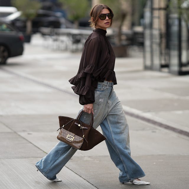 Light Wash Baggy Jeans With Ruffled Blouse And Brown Handbag — Trendy Baggy Jeans Outfits
