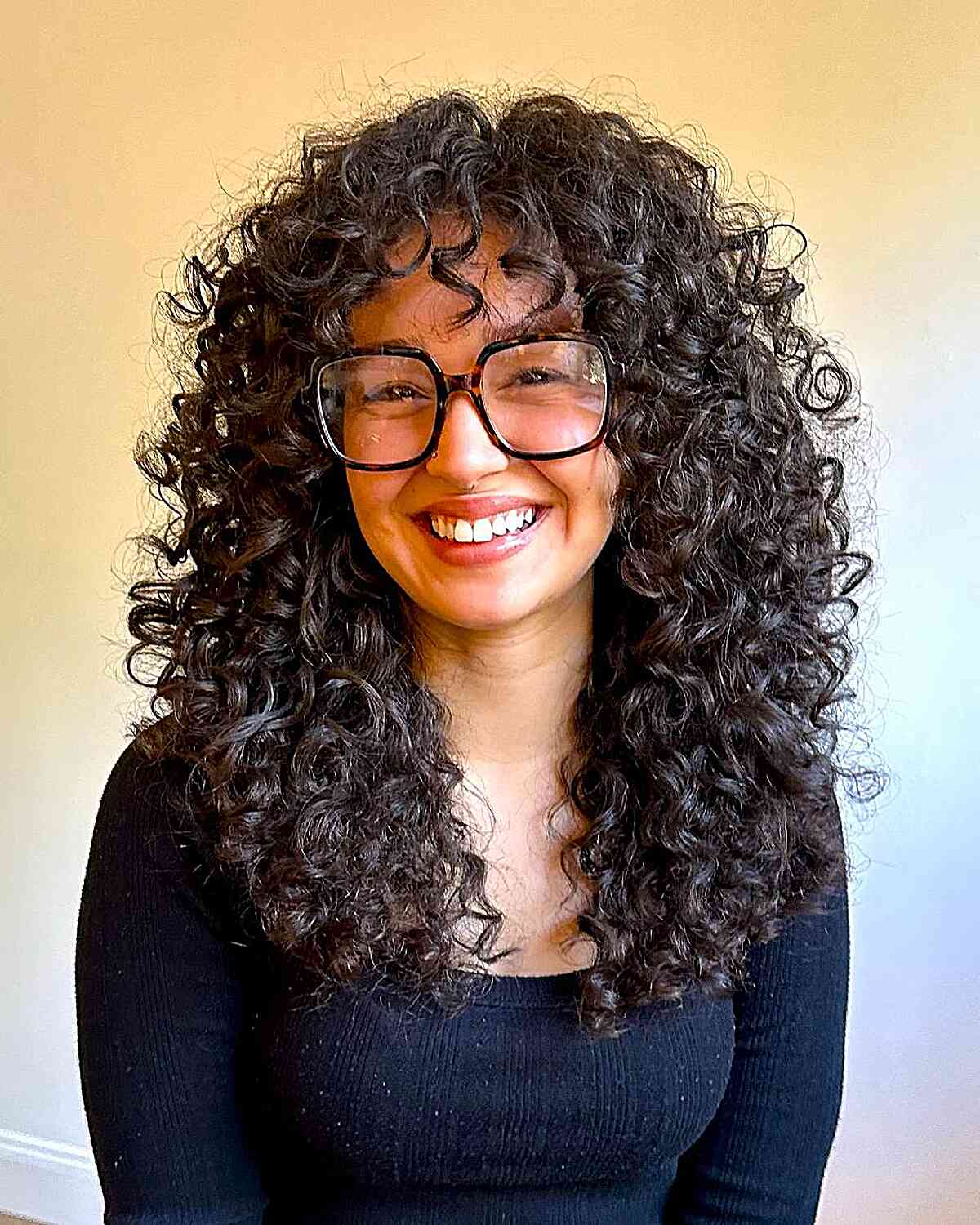 Mid-Back Curly Hair With Full Bangs Mid-Back Curly Hair With Full Bangs — Trendy Brown Curly Hair