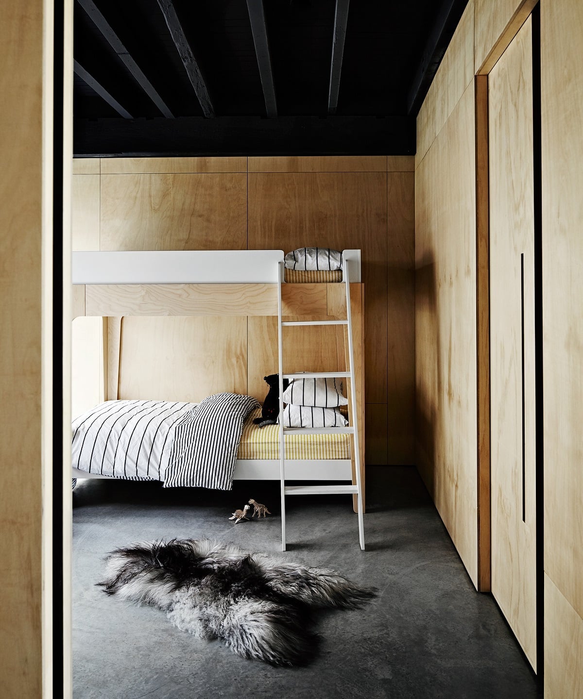 White Bunk Bed with Striped Bedding and Fluffy Rug — Trendy Bunk Bed Ideas