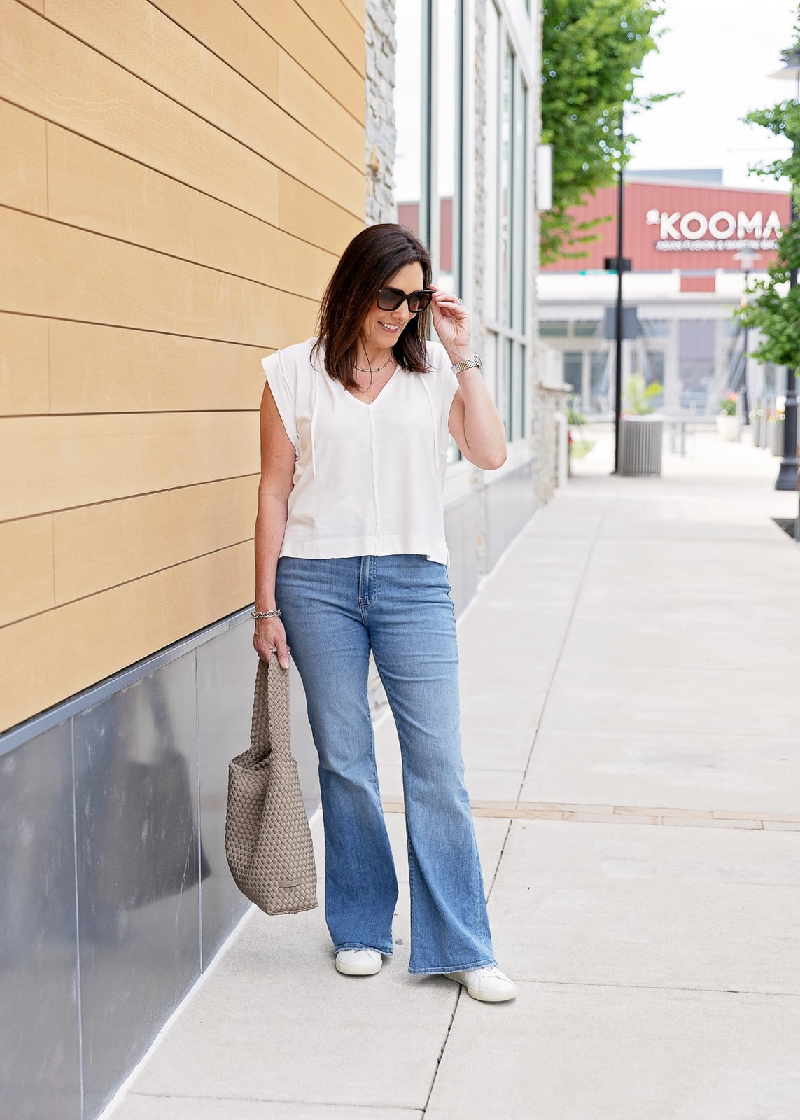 White V-Neck Top With Flare Jeans And Woven Tote White V-Neck Top With Flare Jeans And Woven Tote — Trendy Casual Concert Outfit