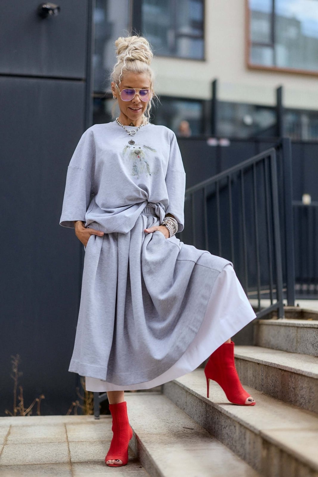 Oversized Graphic Tee with a Pleated Skirt and Silver Necklace — Trendy Graphic Tee Outfits