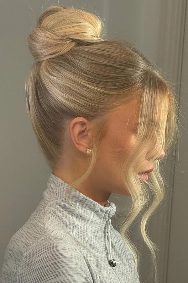 Sleek Platinum Blonde Bun With Wispy Bangs — Trendy High Bun Hairstyles